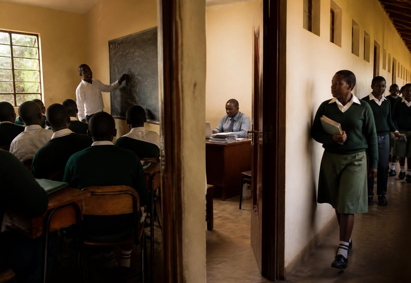 A lesson in progress, the school office at work and pupils in the corridor.